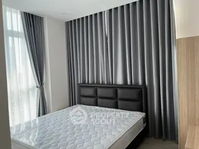Modern bedroom with large window and elegant gray curtains, featuring a comfortable bed and stylish decor.