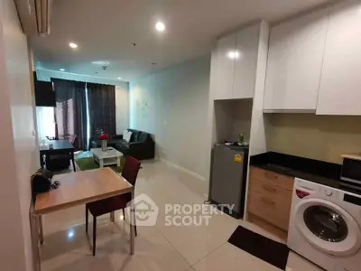 Modern open-plan living room with kitchen, featuring washing machine and stylish decor.