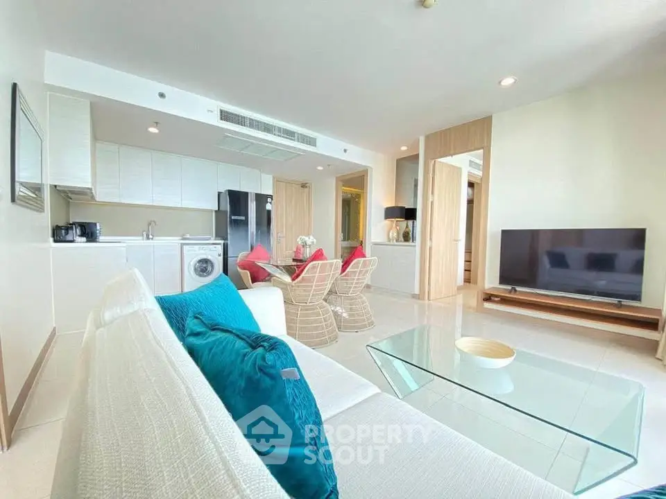 Spacious modern living room with open kitchen, stylish furniture, and abundant natural light.
