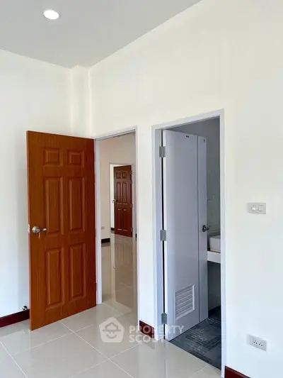 Bright interior with wooden doors and tiled flooring, showcasing modern design.