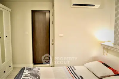 Cozy bedroom with modern decor and air conditioning, perfect for relaxation.