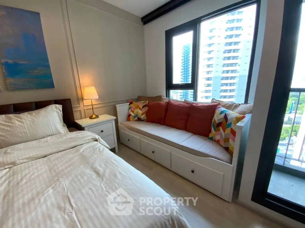 Cozy bedroom with large windows and stylish seating area in modern apartment