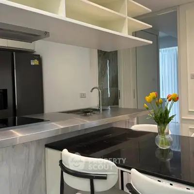 Modern kitchen with sleek design, featuring stainless steel appliances and elegant dining area.