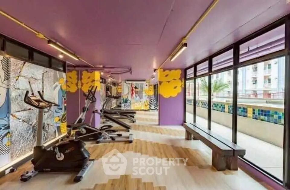 Vibrant gym with modern equipment and colorful decor in a residential building.