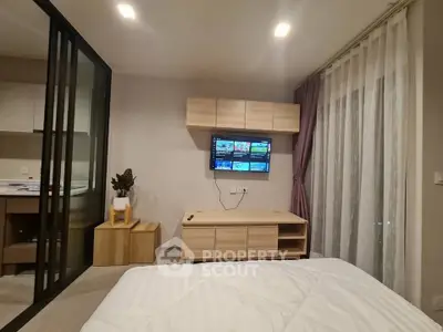 Modern bedroom with sleek furniture and wall-mounted TV, featuring a cozy ambiance and stylish decor.