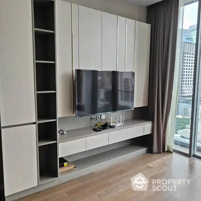 Modern living room with sleek TV unit and city view from large windows