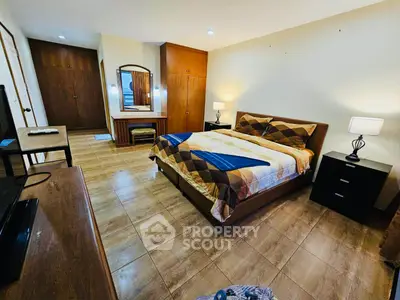 Spacious bedroom with modern furnishings and warm lighting, ideal for comfort and relaxation.