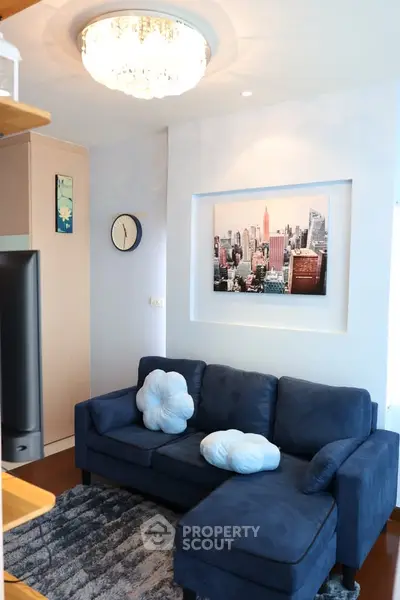 Chic living room with plush blue sofa and modern decor in a stylish apartment.