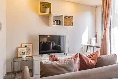 Modern living room with stylish decor and natural light, featuring a sleek TV setup and cozy seating area.