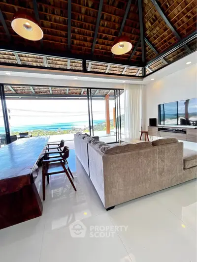 Luxurious living room with ocean view, high ceilings, and elegant furnishings in a modern open layout.