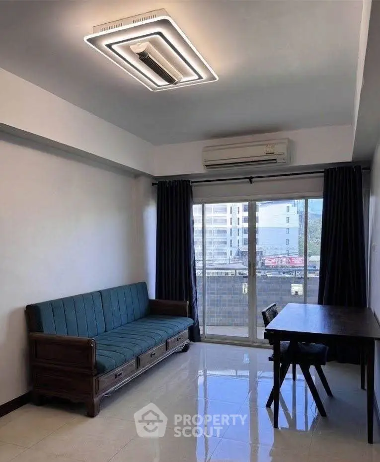 Modern living room with sleek furniture and large window offering city views.