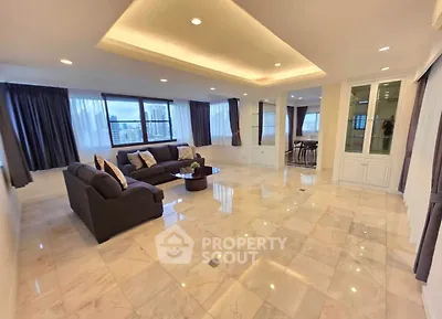 Spacious living room with elegant marble flooring and large windows offering city views.