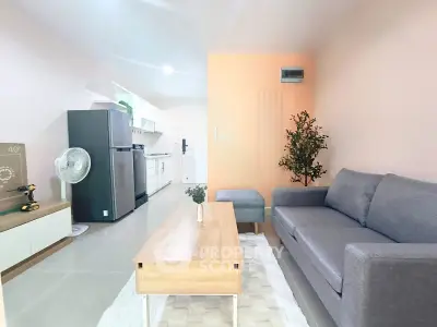 Modern living room with sleek furniture and open kitchen layout in stylish apartment.