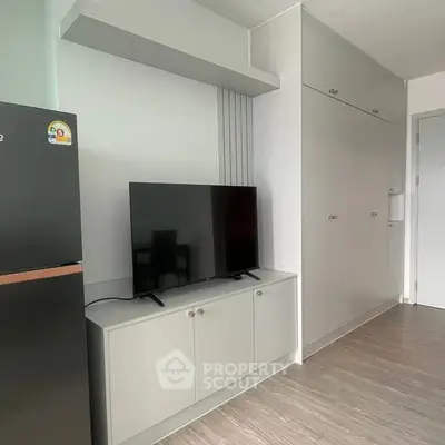 Modern apartment interior with sleek TV setup and fridge