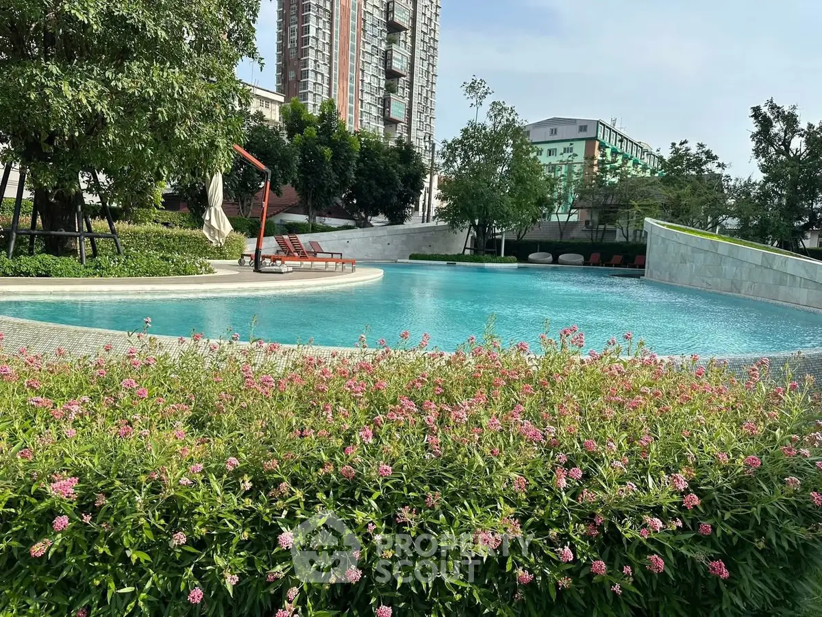 Luxurious residential pool surrounded by lush greenery and modern architecture.