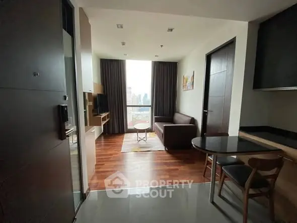 Modern apartment living room with city view, wooden flooring, and stylish furniture.
