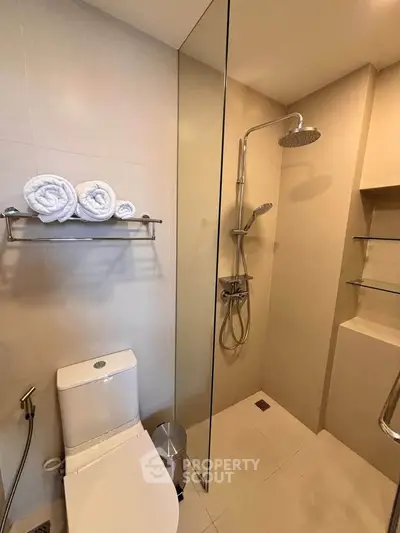 Modern bathroom with glass shower and sleek fixtures in a contemporary apartment.