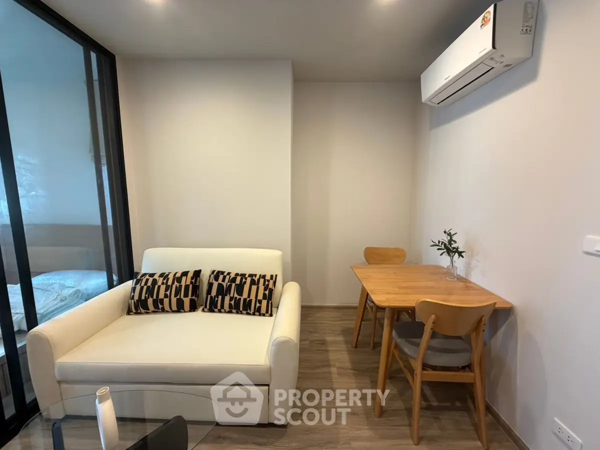Modern living room with cozy sofa, dining table, and air conditioning in a stylish apartment.