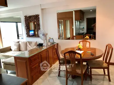 Charming living room with elegant wooden dining set and cozy sofa, perfect for family gatherings.