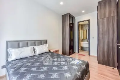 Modern bedroom with stylish furniture and ensuite bathroom in a contemporary apartment.