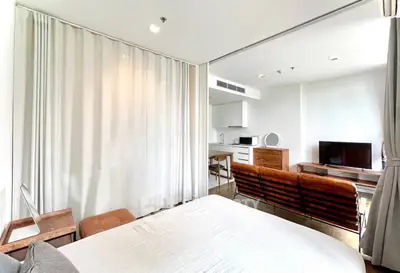 Modern studio apartment with open layout, featuring cozy living area and sleek kitchen.