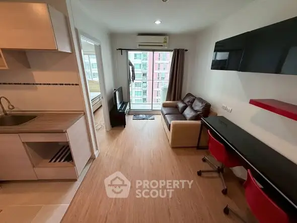 Modern apartment interior with open layout, featuring living room, kitchen, and study area.