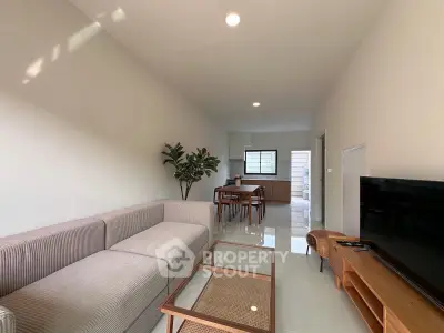 Spacious modern living room with cozy sofa and dining area, perfect for relaxation and entertainment.