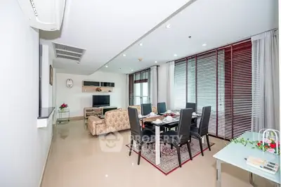 Spacious living room with dining area and modern decor in a bright apartment.