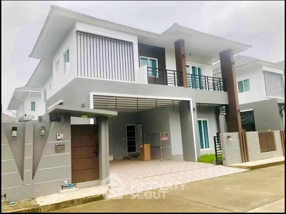 Modern two-story house with sleek design and spacious driveway in a suburban neighborhood.