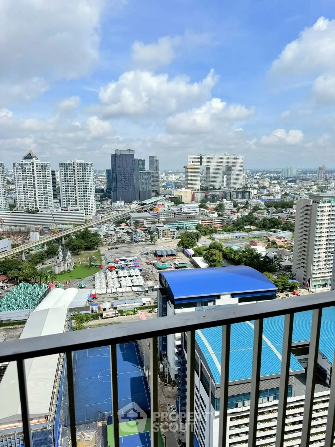 Stunning cityscape view from high-rise balcony with clear blue sky