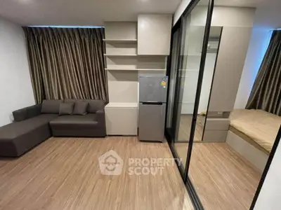 Modern studio apartment with sleek design and wooden flooring, featuring a cozy living area and compact sleeping space.