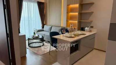 Modern open-layout living room with elegant kitchen and cozy seating area, perfect for urban living.