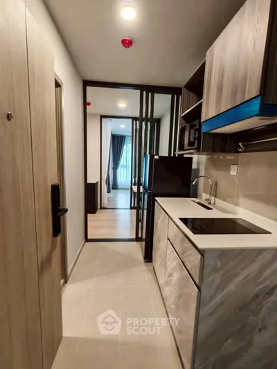 Modern compact kitchen with sleek design and integrated appliances in a stylish apartment.