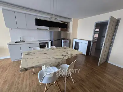 Modern kitchen with marble dining table and sleek appliances in open layout