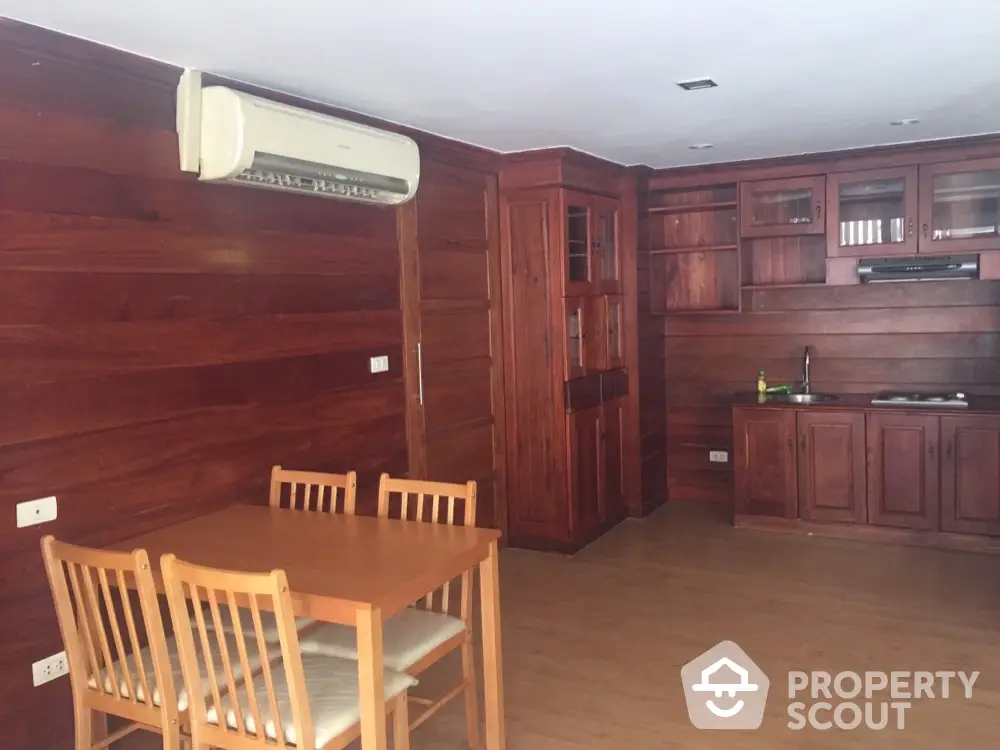 Spacious wooden kitchen with dining area and air conditioning unit