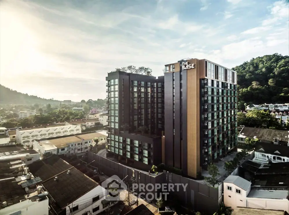 Stunning modern condominium building with panoramic city views and lush surroundings.