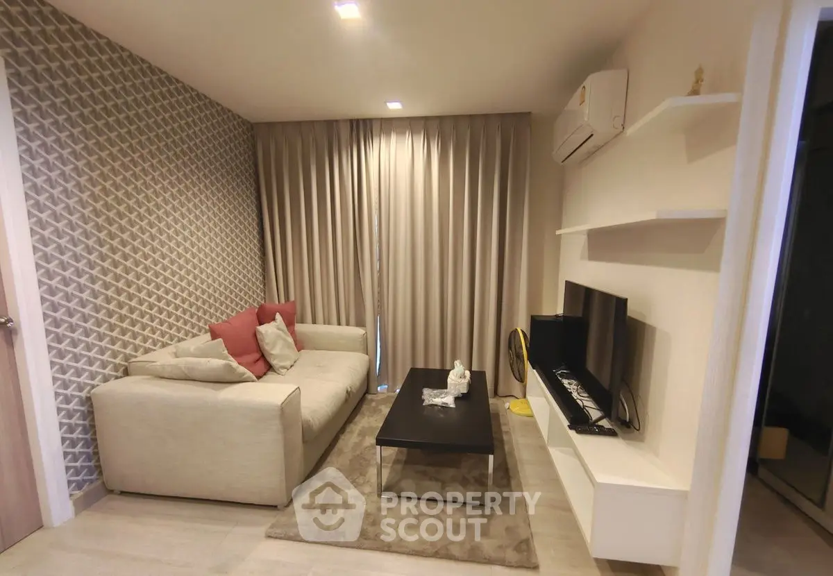 Modern living room with cozy sofa, stylish decor, and wall-mounted TV in a chic apartment.