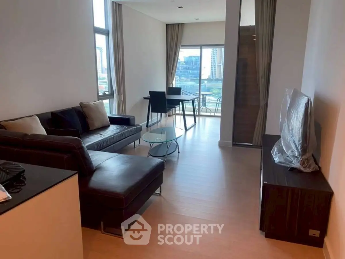 Modern living room with sleek furniture and city view balcony