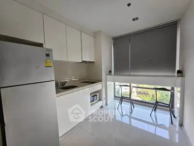 Modern kitchen with sleek white cabinets and large window view