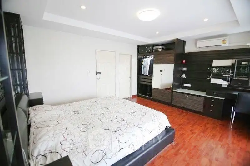 Spacious modern bedroom with elegant wooden flooring and built-in wardrobe