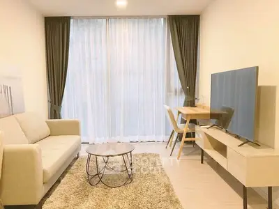 Modern living room with cozy sofa, stylish table, and large TV, perfect for relaxation and entertainment.