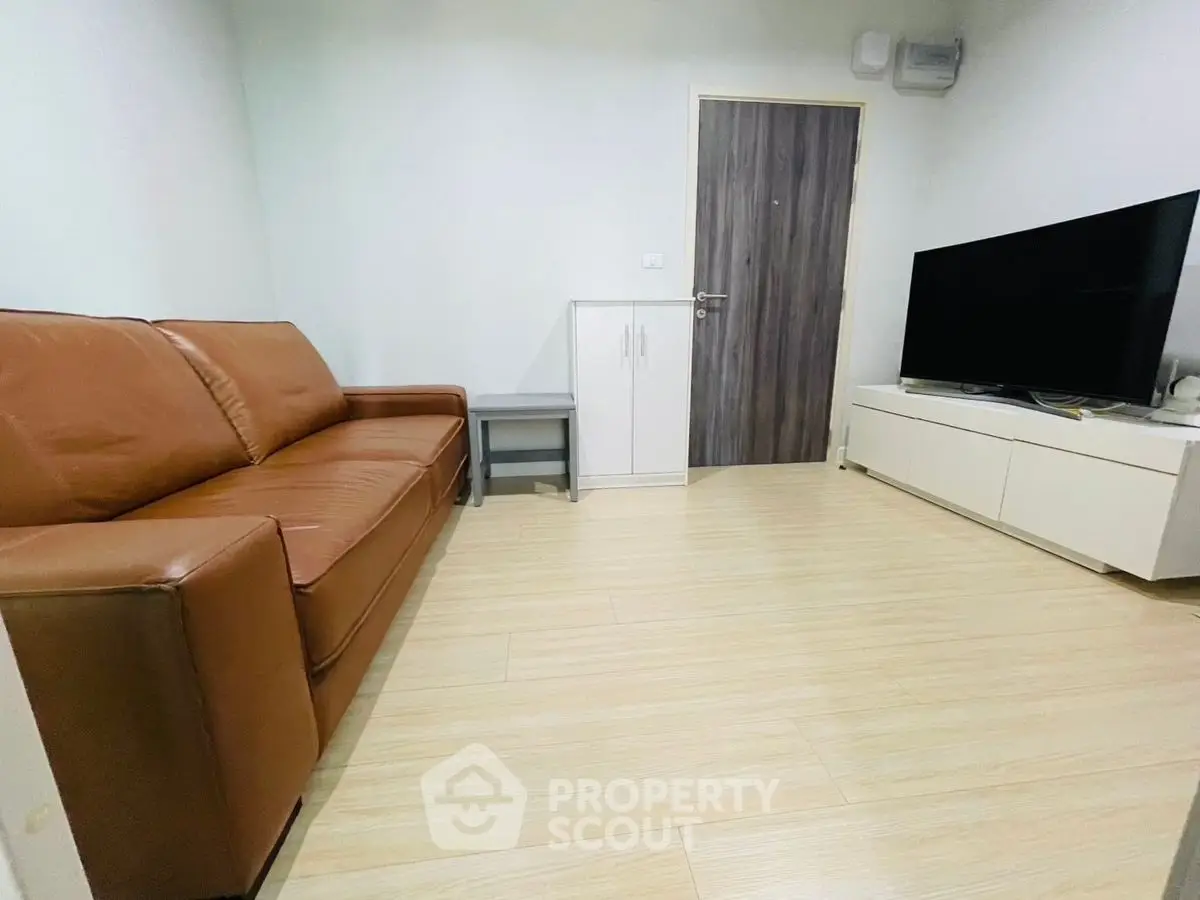Cozy living room with brown leather sofa and modern TV setup