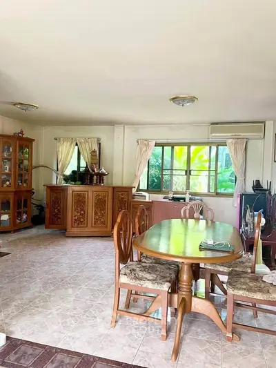 Spacious living room with elegant wooden furniture and large windows offering natural light.