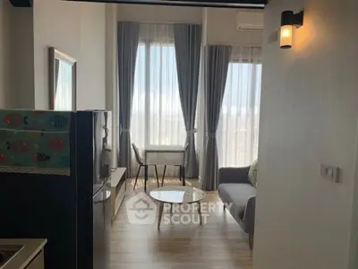 Modern living room with large windows and stylish decor in a high-rise apartment.
