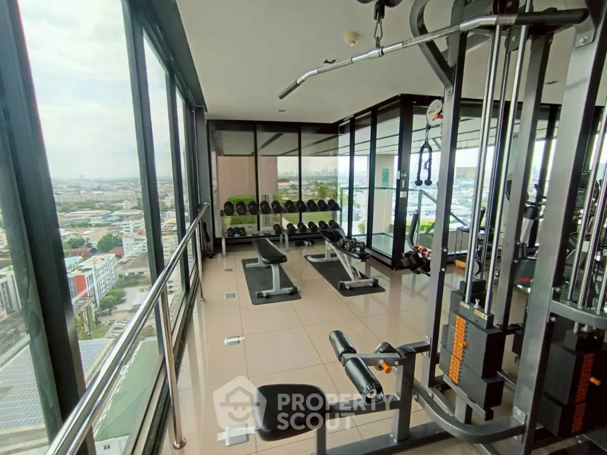 High-rise gym with panoramic city views and modern fitness equipment.