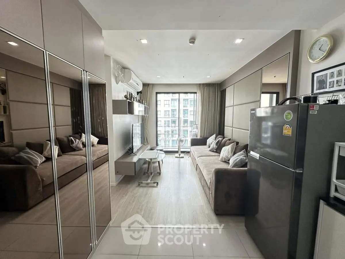 Modern living room with sleek design, mirrored walls, and large windows offering city views.