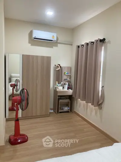 Cozy bedroom with wooden wardrobe, mirror, and air conditioning, perfect for comfortable living.