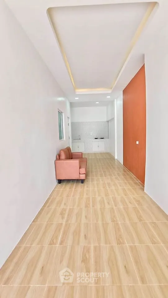 Spacious modern living room with sleek wooden flooring and stylish recessed lighting.