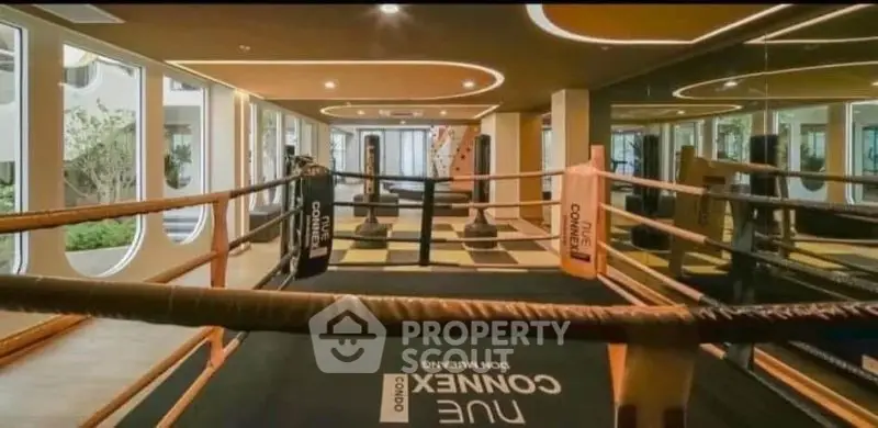 Luxurious gym with boxing ring and modern design in upscale property.