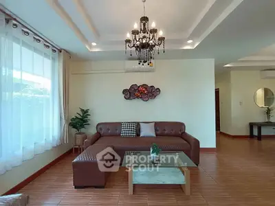 Spacious living room with elegant chandelier and modern furniture